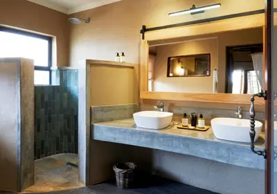 a bathroom with two sinks and a mirror at Motswari Private Game Reserve by NEWMARK in Timbavati Game Reserve