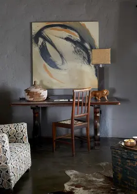 a room with a desk with a chair and a painting at Motswari Private Game Reserve by NEWMARK in Timbavati Game Reserve