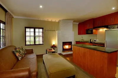 a kitchen and living room with a couch and a fireplace at Dunkeld Country & Equestrian Estate in Dullstroom