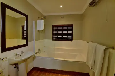a bathroom with a tub and a sink and a mirror at Dunkeld Country & Equestrian Estate in Dullstroom