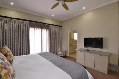 a bedroom with a bed and a flat screen tv at Dunkeld Country & Equestrian Estate in Dullstroom