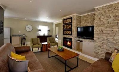 a living room with a couch and a fireplace at Dunkeld Country & Equestrian Estate in Dullstroom