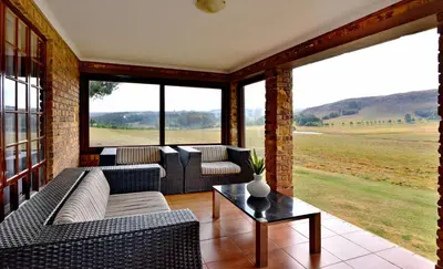 a living room with couches and a table at Dunkeld Country & Equestrian Estate in Dullstroom