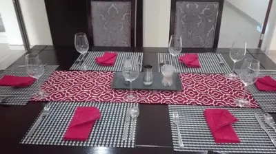 a dining table with red napkins and glasses on it at Estoby Executive guest house in Witbank