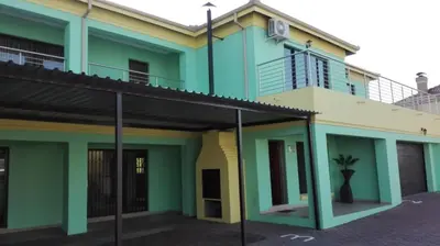 a green and yellow building with a balcony at Estoby Executive guest house in Witbank