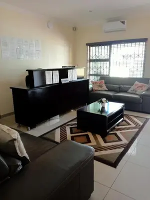 a living room with a couch and a coffee table at Estoby Executive guest house in Witbank