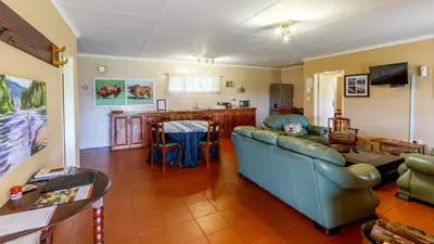 a living room with a couch and a table at Hoyohoyo Machadostud Lodge in Helvetia Noord