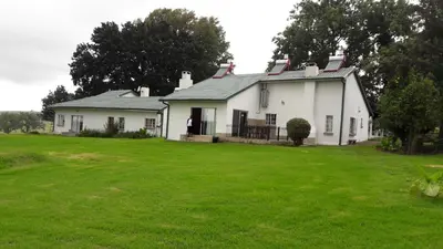a large white house with a large yard at Hoyohoyo Machadostud Lodge in Helvetia Noord