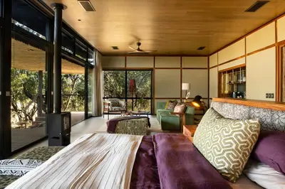 a bedroom with a bed and a living room at Tanda Tula Safari Camp in Timbavati Game Reserve