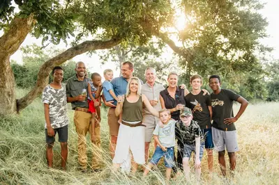 a large family posing for a picture in a field at Tanda Tula Safari Camp in Timbavati Game Reserve