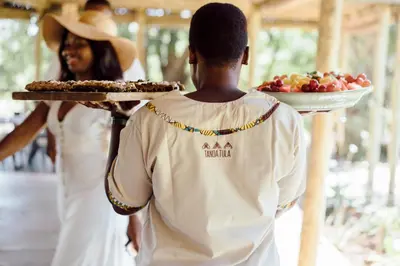 a man holding a plate of food with a woman at Tanda Tula Safari Camp in Timbavati Game Reserve