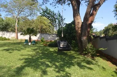 a yard with a tree and a fence at Holiday Flat Stormvoel 547 in Hazyview