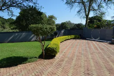 a brick walkway with a small tree in a yard at Holiday Flat Stormvoel 547 in Hazyview