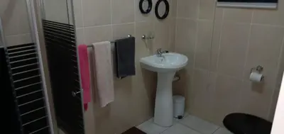 a bathroom with a sink and a shower with towels at Horizon View Chalets in Graskop