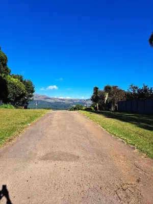 an empty road in a field with a blue sky at Horizon View Chalets in Graskop