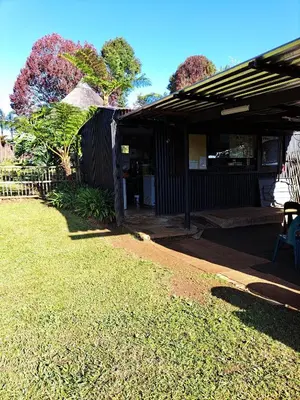 a house with a porch and a grass yard at Horizon View Chalets in Graskop