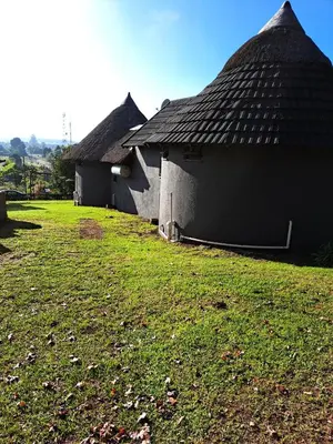 two buildings with a grassy yard in front of them at Horizon View Chalets in Graskop