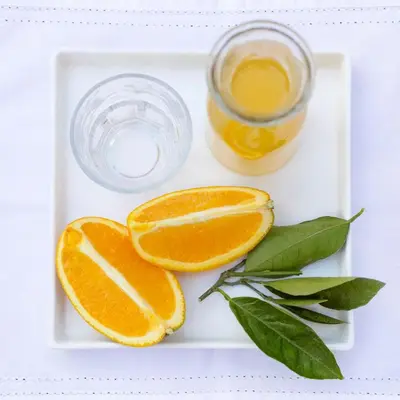 a plate with orange slices and a glass of orange juice at Brooklyn Manor in Pretoria