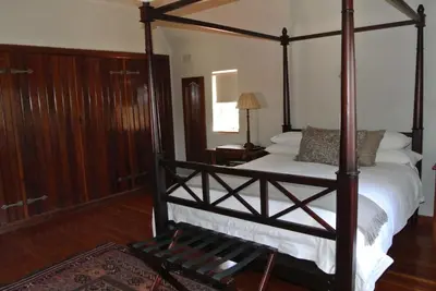 a bedroom with a four poster bed with white sheets at Brooklyn Manor in Pretoria
