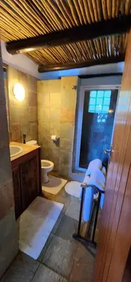 a bathroom with a sink and a toilet and a window at Bali at Scenic Haven Lodge in Hartbeespoort in Hartbeespoort