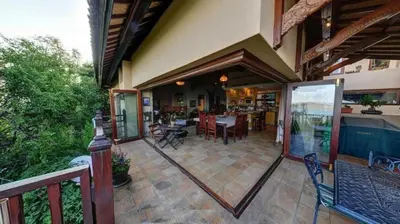 a porch of a house with a table and chairs at Bali at Scenic Haven Lodge in Hartbeespoort in Hartbeespoort