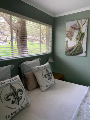 a bedroom with a bed with two pillows and a window at Nightjar Guest Lodge in Nelspruit