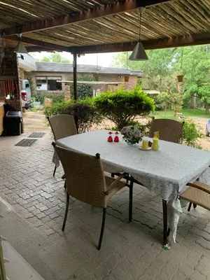 a white table and chairs on a patio at Nightjar Guest Lodge in Nelspruit