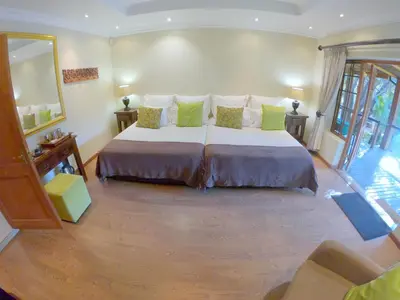 a bedroom with a large bed in a room at Tuskers Bush Lodge B&B in Hartbeespoort