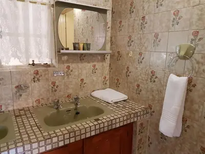 a bathroom with a sink and a mirror at Marlot Guest House in Polokwane