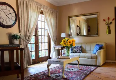 a living room with a couch and a clock and a table at Irene B&B in Irene