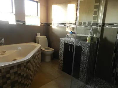 a bathroom with a tub and a toilet and a sink at Lion King in Marloth Park