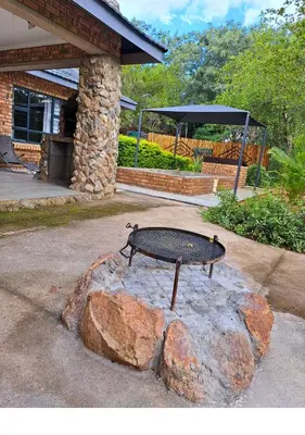 a bench sitting on top of a rock with a large rock at Lion King in Marloth Park