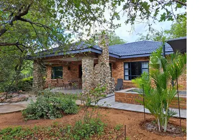 a brick house with a tree in front of it at Lion King in Marloth Park
