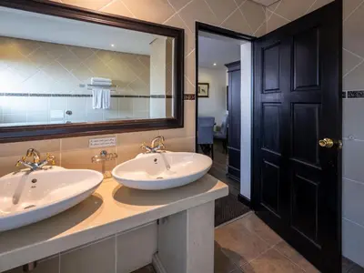 a bathroom with two sinks and a large mirror at ANEW Hotel Witbank Emalahleni in Witbank