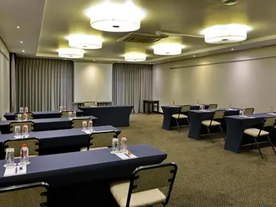 a conference room with blue tables and chairs at ANEW Hotel Witbank Emalahleni in Witbank