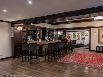 a bar in a restaurant with people sitting at a counter at ANEW Hotel Witbank Emalahleni in Witbank