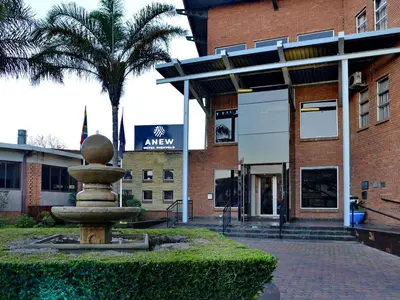 a fountain in front of a building with a palm tree at ANEW Hotel Highveld Emalahleni in Witbank