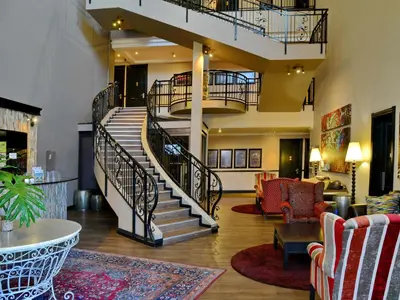 a lobby with a spiral staircase and a living room at ANEW Hotel Highveld Emalahleni in Witbank