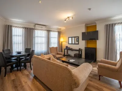 a living room with a table and chairs at ANEW Hotel Highveld Emalahleni in Witbank