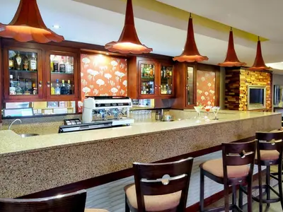 a kitchen with a bar with bar stools at ANEW Hotel Highveld Emalahleni in Witbank