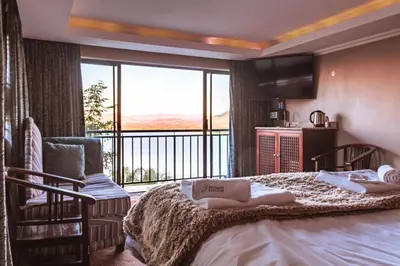 a bedroom with a bed and a large window at Kosmos Lodge in Hartbeespoort