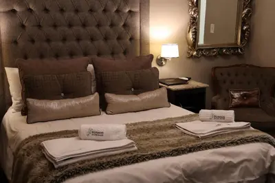 a bedroom with a large bed with towels on it at Kosmos Lodge in Hartbeespoort