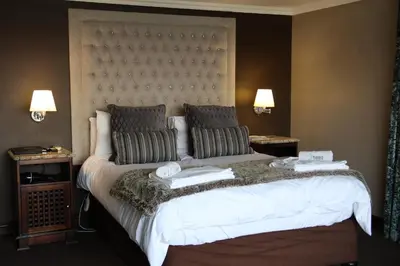 a bedroom with a large bed with two pillows at Kosmos Lodge in Hartbeespoort
