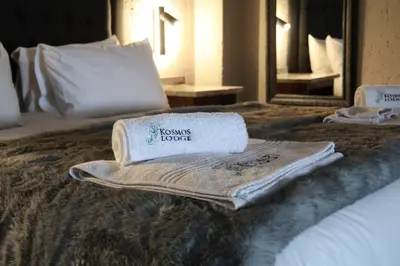 a hotel room with towels on a bed at Kosmos Lodge in Hartbeespoort