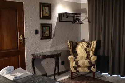a room with a table and a chair and a table and a chair at Kosmos Lodge in Hartbeespoort