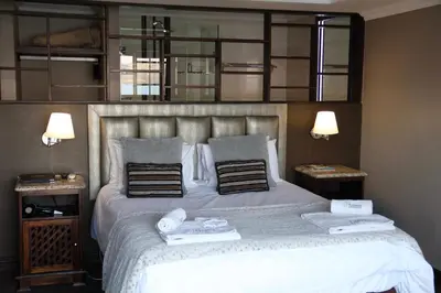 a bedroom with a bed with two towels on it at Kosmos Lodge in Hartbeespoort