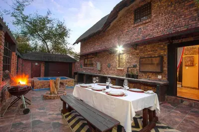 a table on a patio with a grill and a tableablish at Wildgoose Lodge in Marloth Park