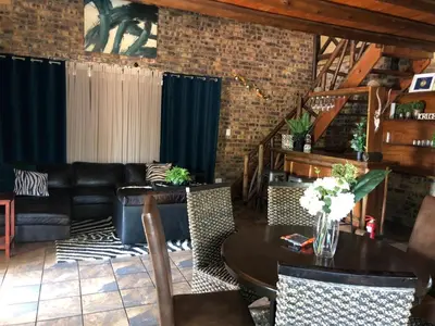 a living room with a couch and a table at Wildgoose Lodge in Marloth Park