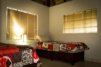 a bedroom with two beds and two windows at Impalas Walk in Marloth Park