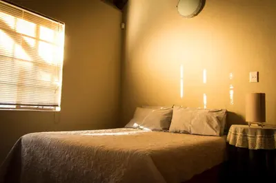 a bedroom with a bed with a clock on the wall at Impalas Walk in Marloth Park